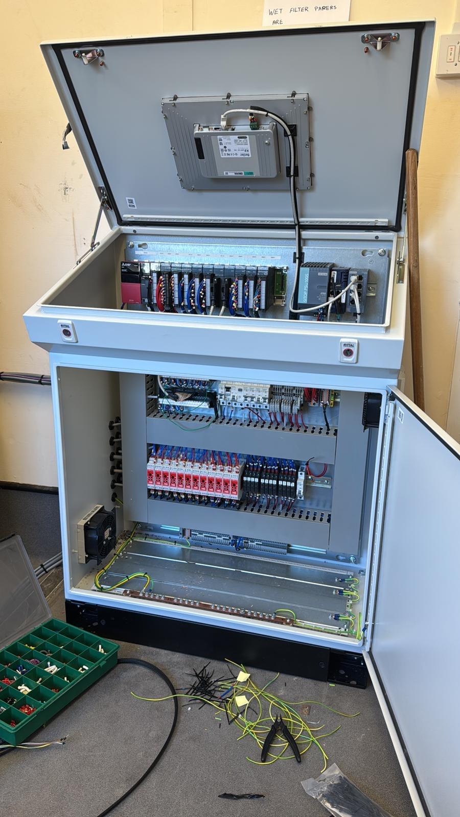 Industrial control panel under assembly with copper busbars and PLC modules
